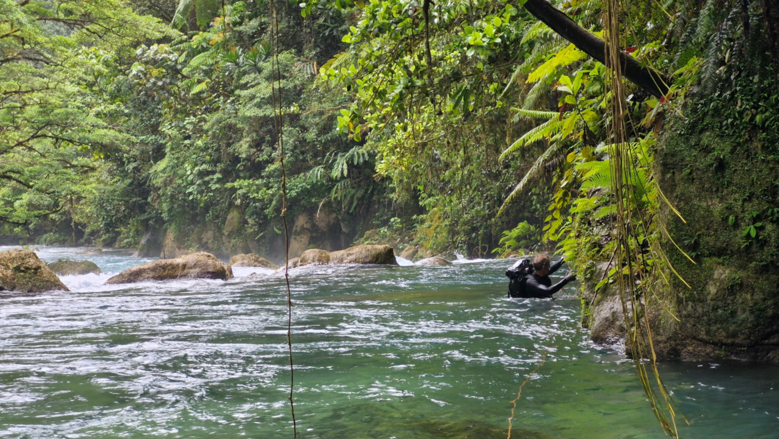 Franck franchit le tronçon de mur en aval pour accéder à la résurgence.