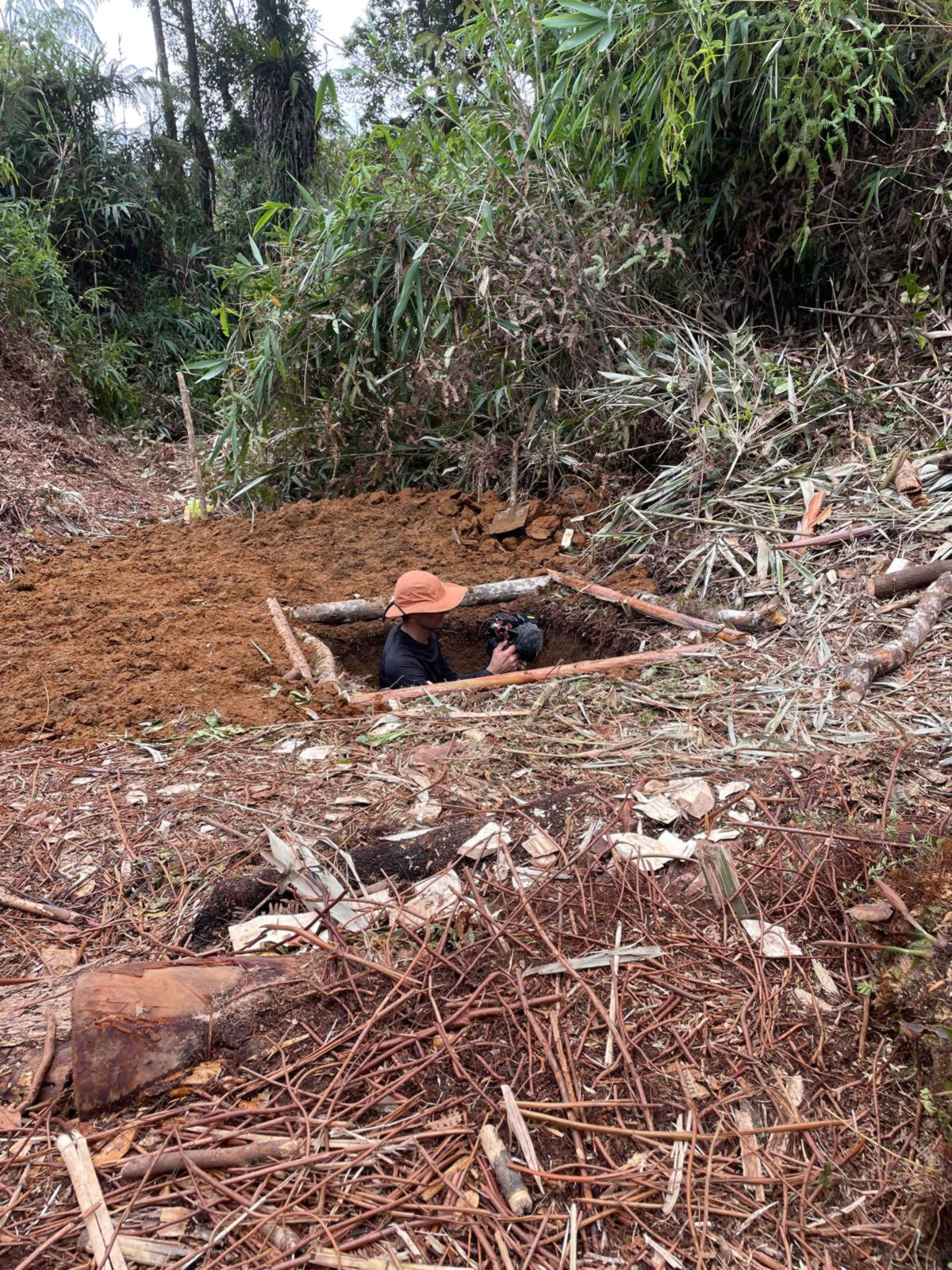 Yann filme les strates visibles dans le trou creusé pour stocker l'eau de pluie.