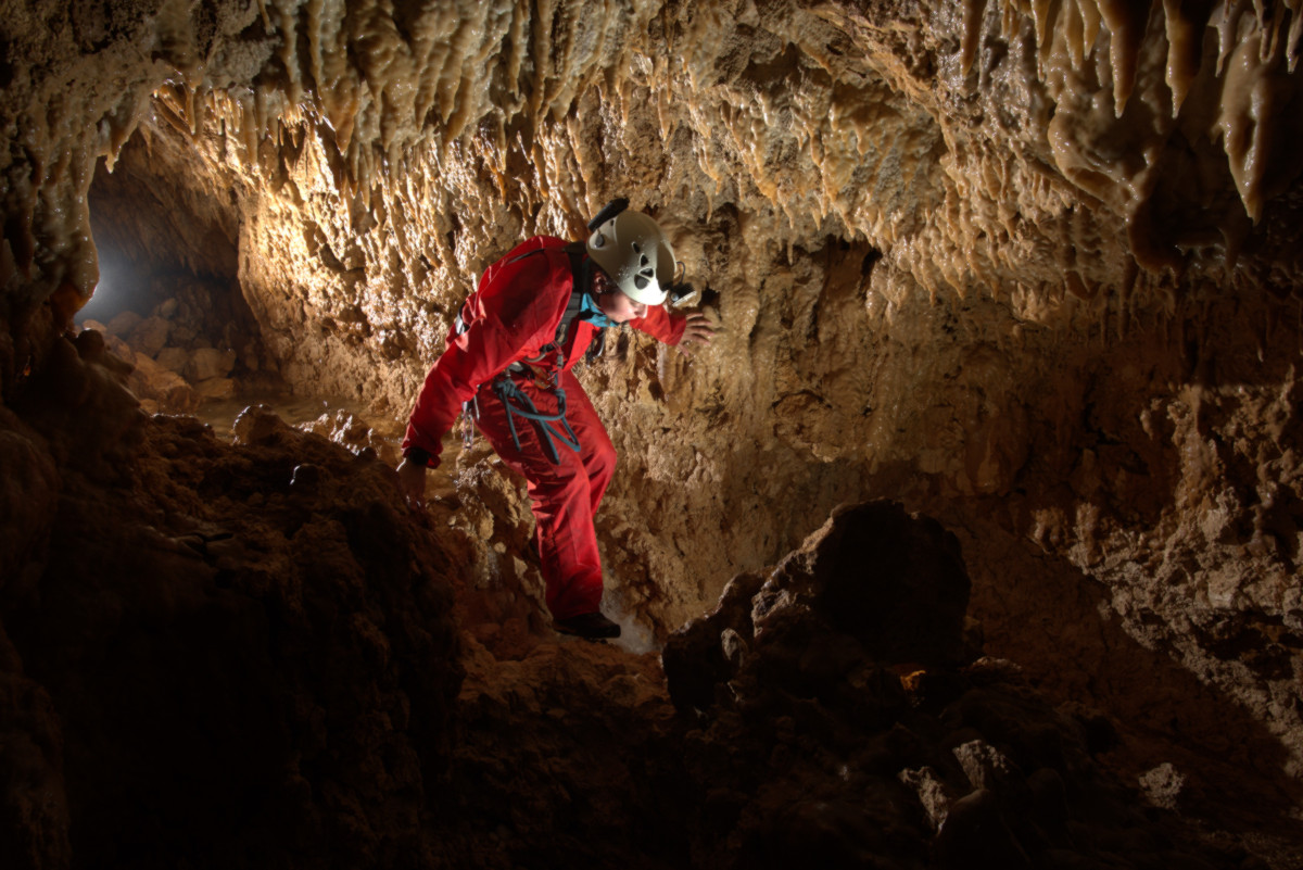 Jessica moves forward in the illuminated emergence cave